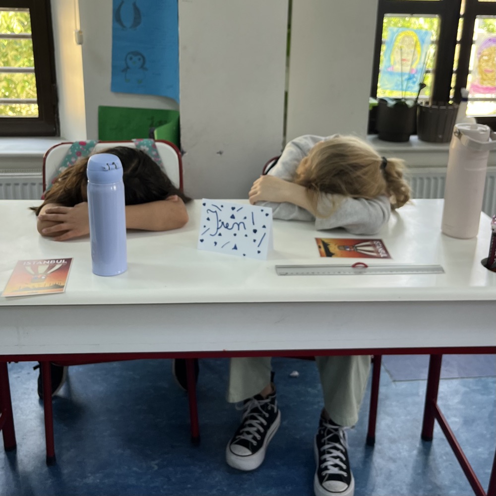 Deux élèves au calme, tête posée sur les bras, pendant une méditation